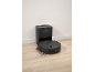 Aspirator robot negru cu stație de golire automată pe podea de lemn.