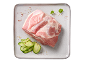 Bucată de carne de porc crudă cu castraveți feliați și ierburi pe o farfurie.