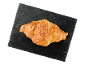 Croissant cu brânză pe o placă neagră de ardezie.