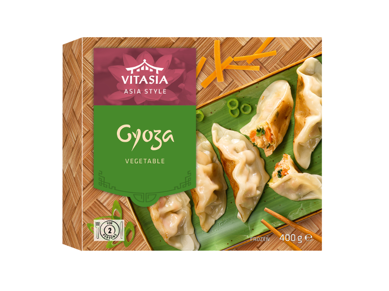 Cutie de gyoza de legume congelate cu o farfurie de gyoza și bețișoare.