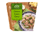 Curry verde de pui cu orez, pe un fundal de bambus cu elemente în stil thailandez.