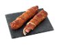 Două covrigei cu cârnați pe o placă neagră de ardezie.
