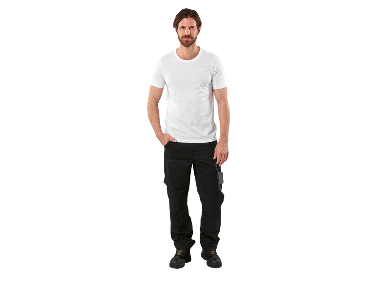 Bărbat în tricou alb și pantaloni de lucru negri cu bocanci de protecție.