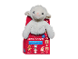O oaie de pluș albă pe o cutie roșie de ciocolate de Crăciun cu umplutură de lapte.