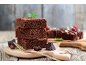 Brownies de ciocolată stivuite cu mentă, ciocolată și alune pe un tocător de lemn.