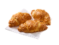 Trei croissante aurii cu brânză pe un șervețel alb de hârtie.