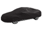 Husă neagră pentru mașină, acoperind complet un vehicul, cu roțile vizibile.