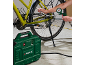Un compresor de aer verde umflă o anvelopă de bicicletă, cu un manometru afișând presiunea.