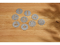 Set de discuri metalice pentru biscuiți cu diverse modele pe o suprafață de lemn.