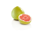 Două pomelo, unul întreg și unul tăiat pe jumătate, cu pulpă roșie