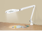 Lampă albă cu lupă LED deasupra unei mese cu materiale de cusut.