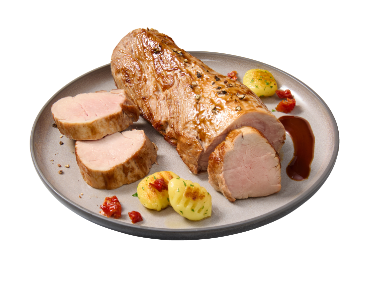 Mușchiuleț de porc fript cu gnocchi și sos brun pe o farfurie.