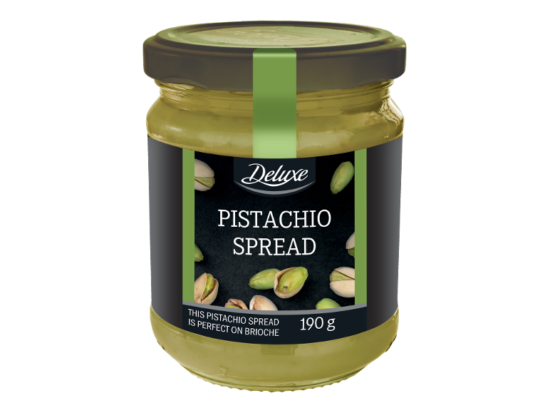 Borcan de cremă de fistic cu fistic împrăștiat și textul „PISTACHIO SPREAD”.