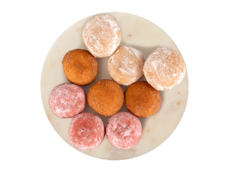 Farfurie rotundă cu gogoși de diverse culori, pudrate cu zahăr.