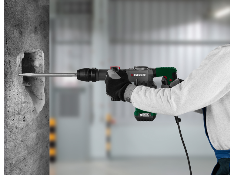 Bărbat care folosește un ciocan rotopercutor pentru a sparge un perete de beton.