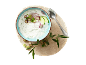 Tzatziki cu castraveți, ceapă roșie și ceapă verde pe un tocător de lemn cu o crenguță de măslin.