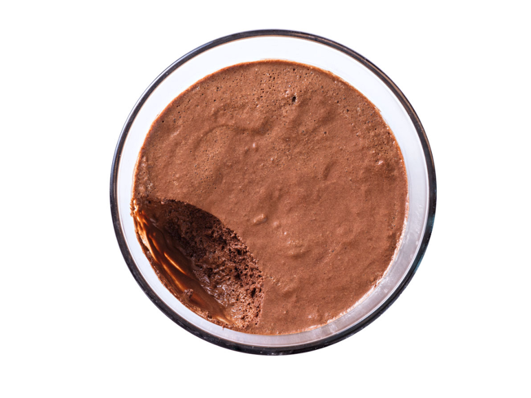 Mousse de ciocolată într-un bol de sticlă cu o bucată lipsă, vedere de sus.
