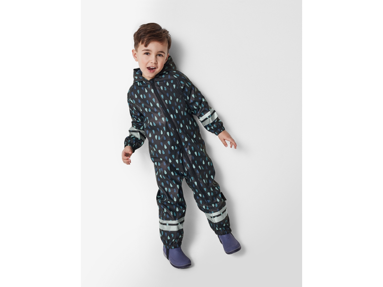 Băiat în costum de ploaie negru cu model de picături de ploaie și cizme de ploaie mov.