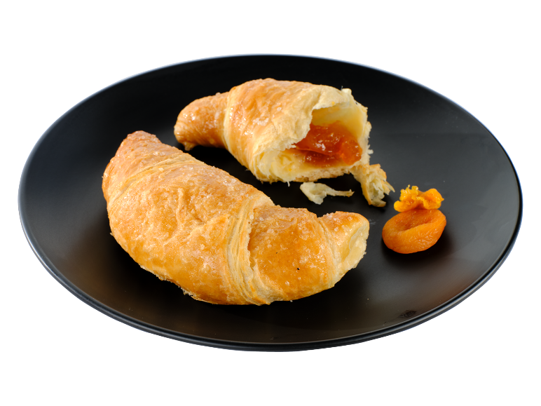 Două croissante aurii, unul cu umplutură de caise, pe o farfurie neagră.
