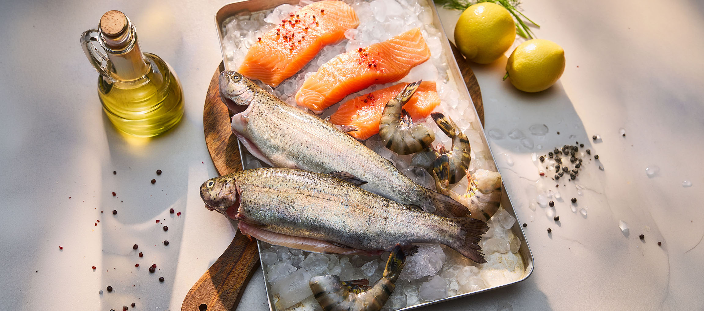 Frischer Fisch und Meeresfrüchte auf Eis, mit Zitronen und Öl.