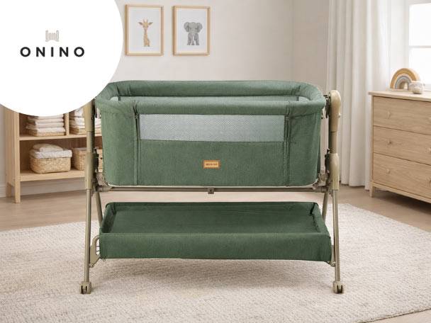 Pătuț de bebeluși verde cu coș de depozitare, într-o cameră luminoasă cu decor minimalist.