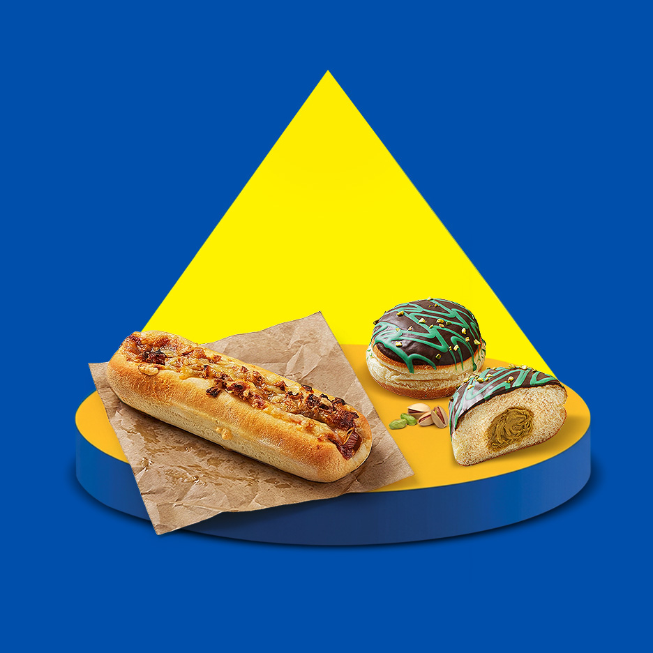 Hot dog cu ceapă caramelizată și gogoși cu ciocolată și fistic pe un fundal albastru și galben.