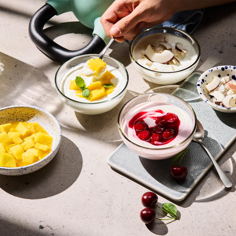 Iaurturi cu fructe și nuci, cu o ganteră în fundal, sugerând o gustare sănătoasă după antrenament.