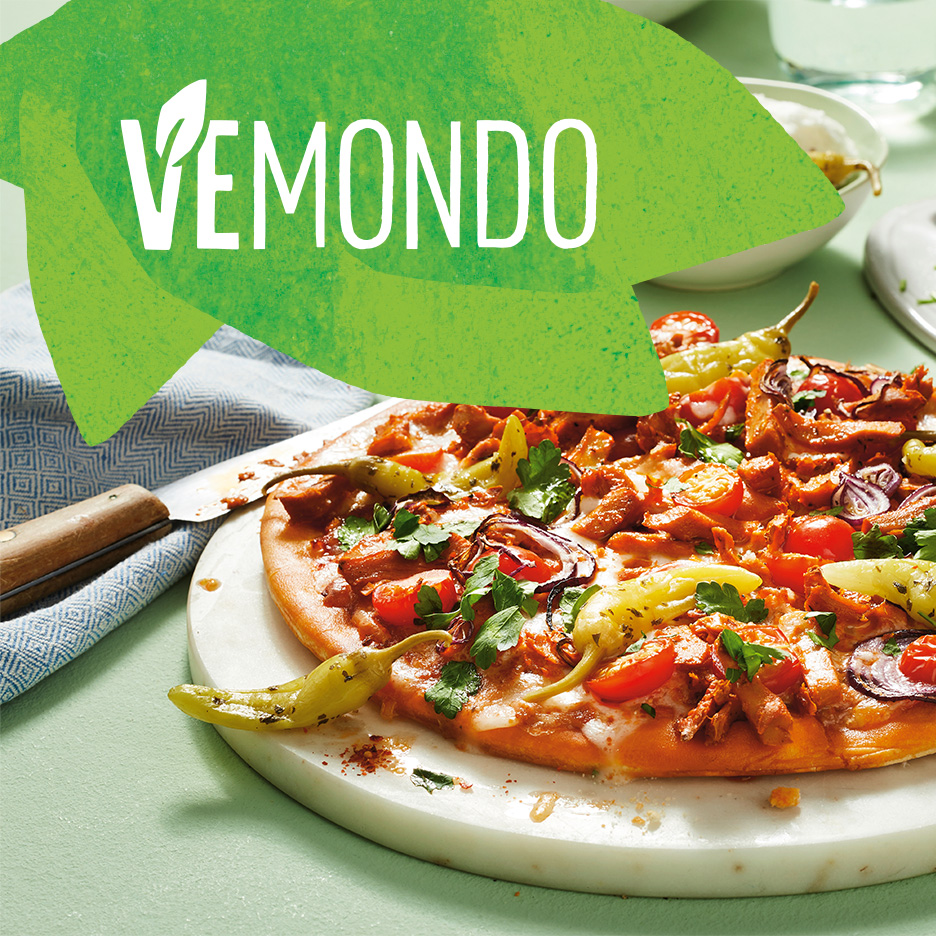 Pizza vegană cu legume și textul 'VEMONDO' pe un fundal verde.