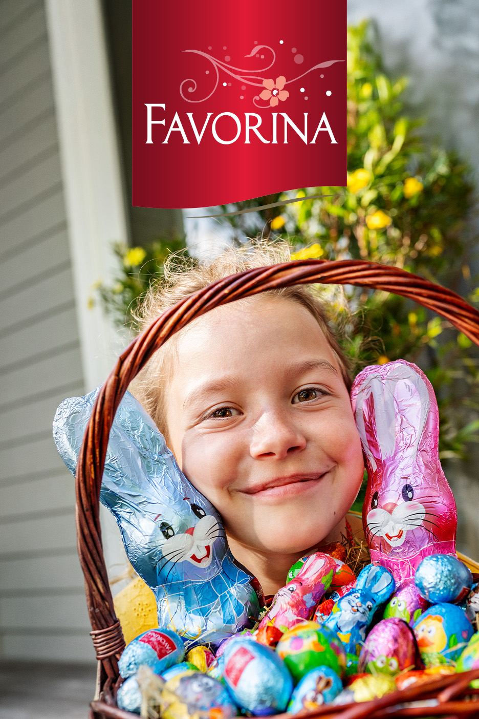 O fetiță zâmbitoare cu un coș plin de iepurași și ouă de ciocolată de Paște.