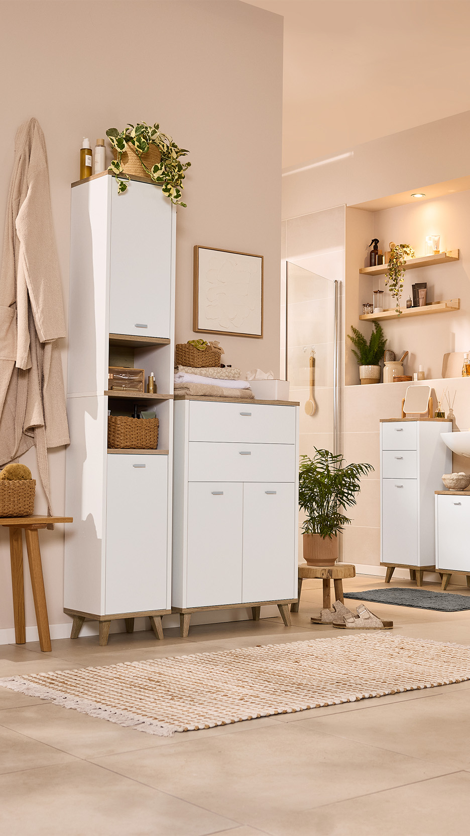 Baie modernă cu dulapuri albe, rafturi din lemn și plante, creând o atmosferă luminoasă și naturală.