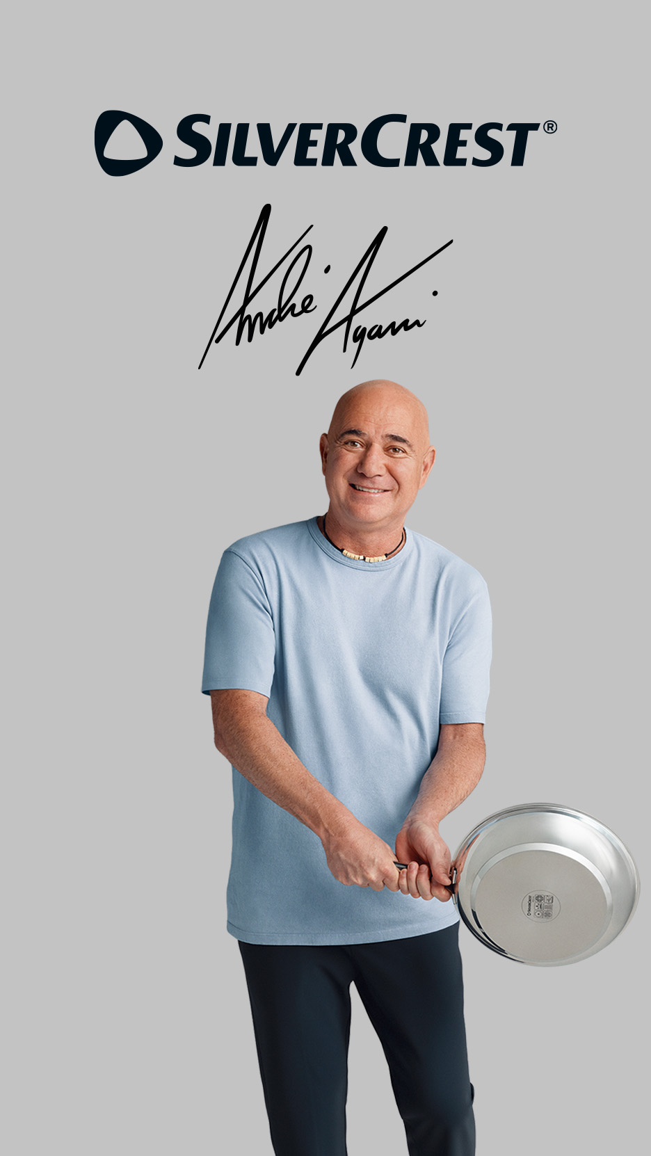 Bărbat zâmbitor, chel, într-un tricou albastru, ținând o tigaie de inox, cu o semnătură deasupra.