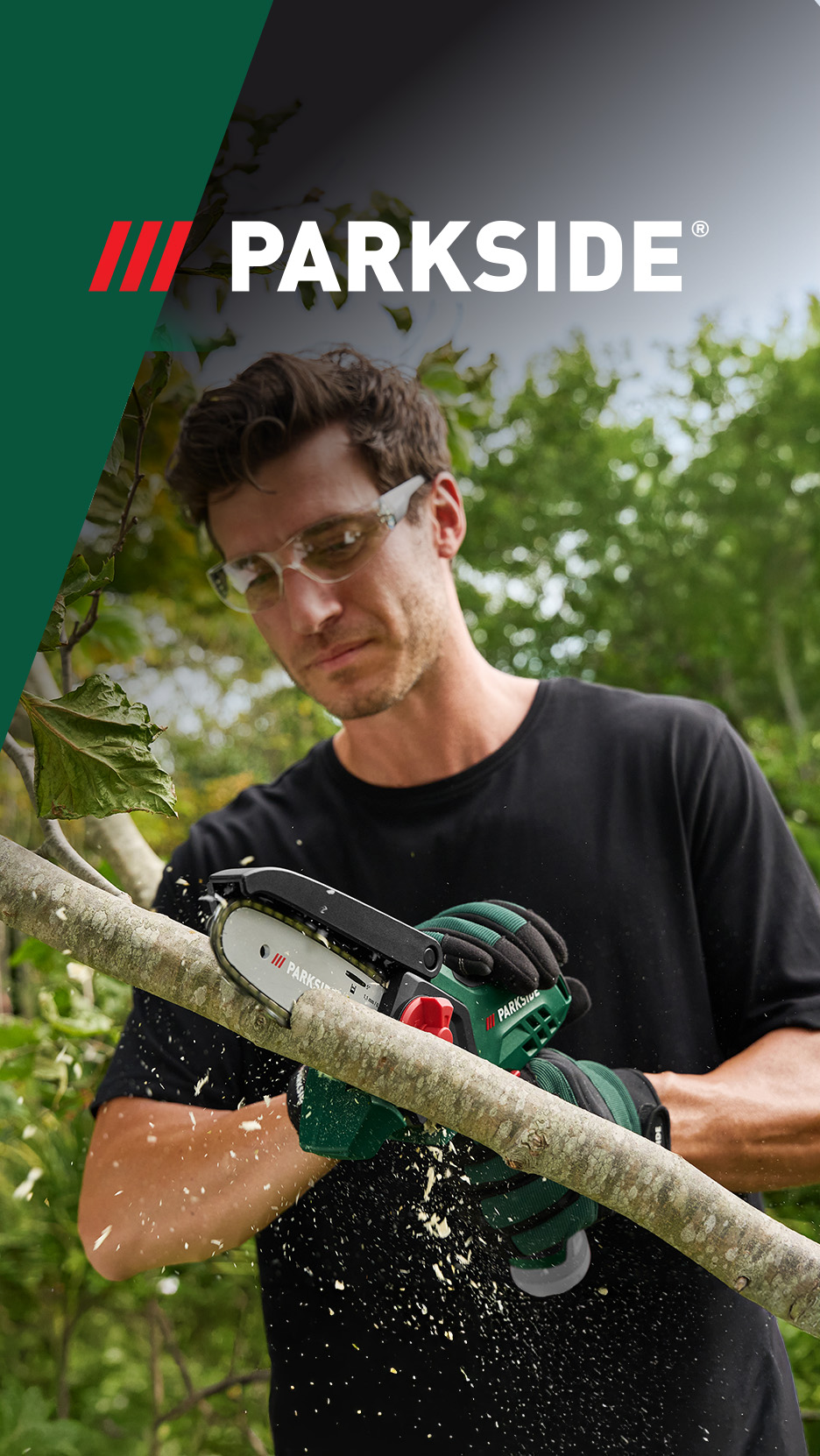 Bărbat tăind o creangă cu un mini-fierăstrău cu lanț, purtând ochelari de protecție și mănuși.