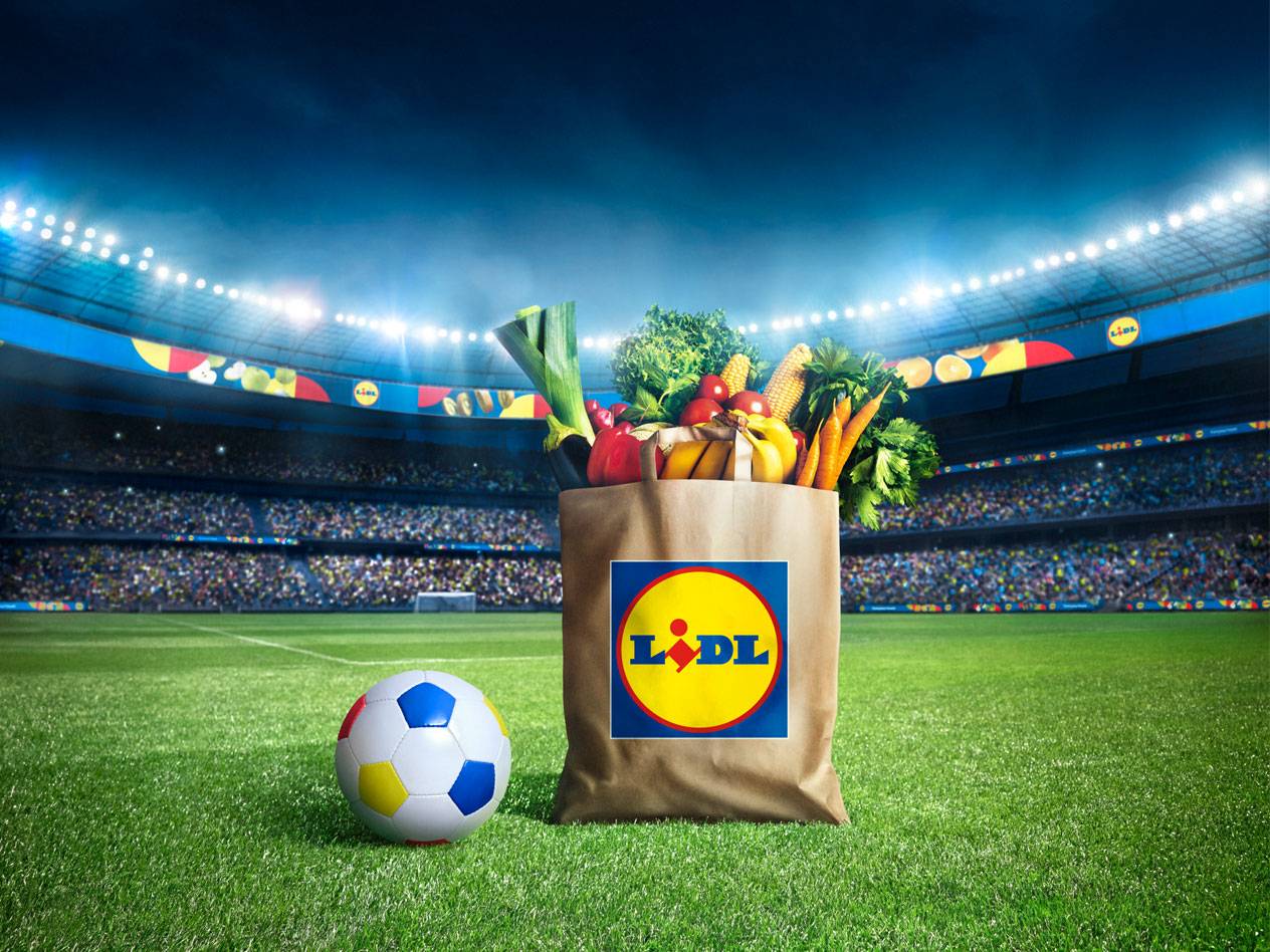 Geantă Lidl cu fructe și legume într-un stadion de fotbal.