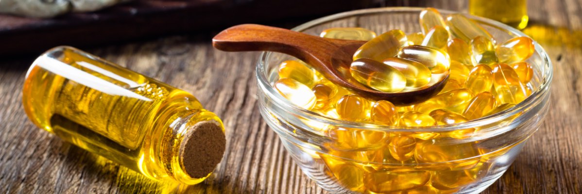 Capsule și ulei omega-3 într-un bol de sticlă.