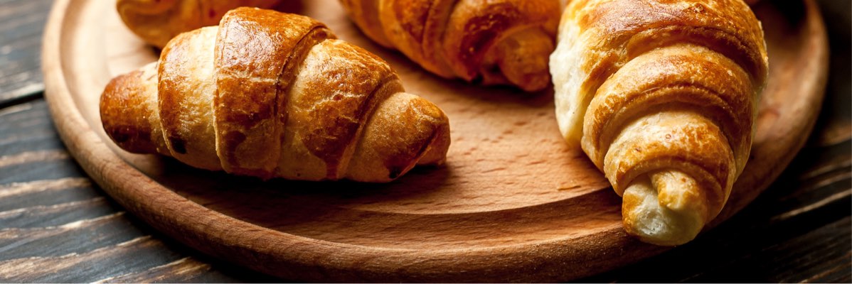 Croissante pe o tavă de lemn.