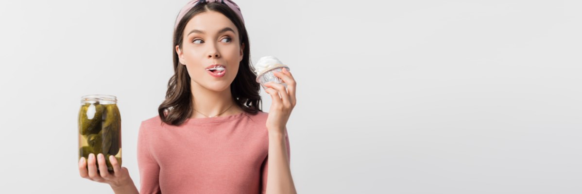 Femeie cu castraveți murați și cupcake.