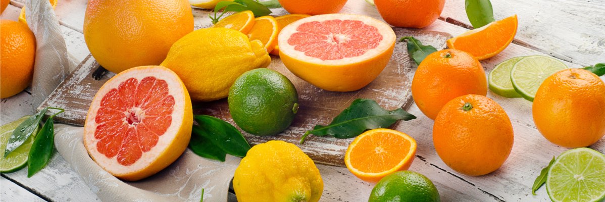 Grapefruit, portocale, lămâi și lime pe o masă din lemn.