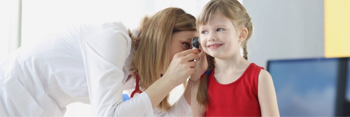 Consulta medicală: Pediatru examinează urechea unui copil.