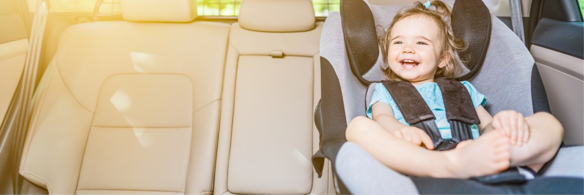 Copil fericit în scaun auto.