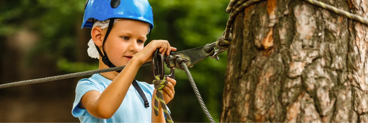 Copil folosind echipament de siguranță într-un parc de aventură.