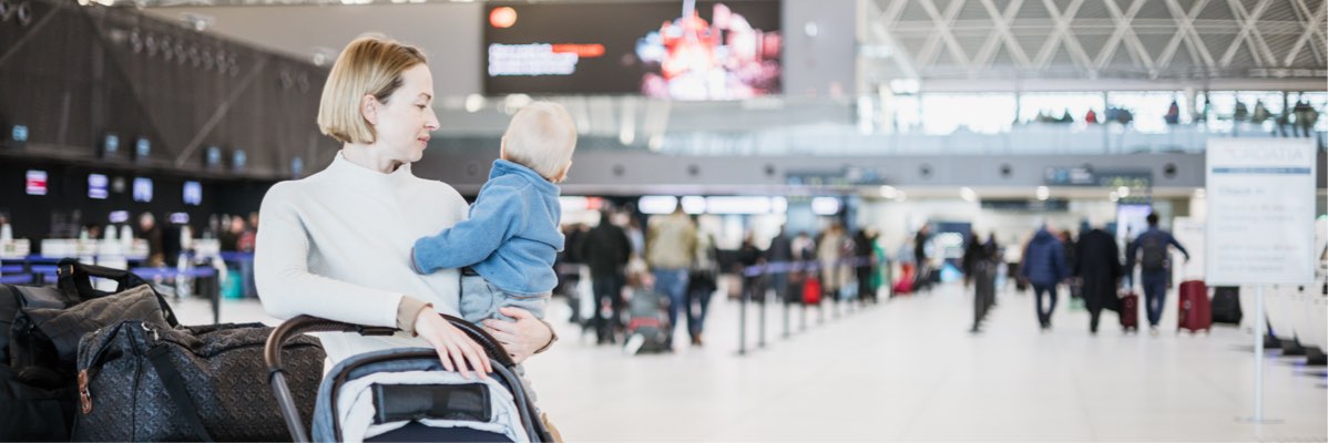 Mamă cu copil și bagaje la aeroport.