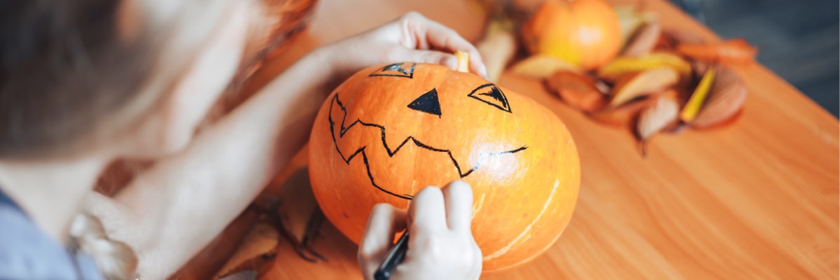 Decorarea dovleacilor de Halloween cu un marker negru.