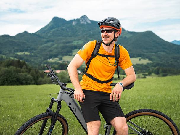 Bicicletă electrică și biciclist într-un peisaj montan.