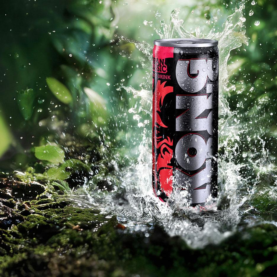 Doză de băutură energizantă cu apă care stropește în jurul ei într-un cadru natural, verde.