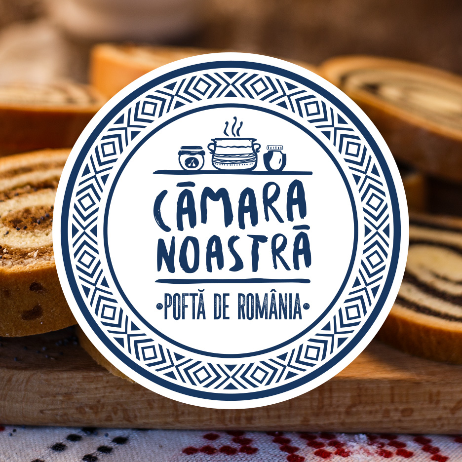 Cozonac feliat cu logo-ul 'Cămara Noastră - Poftă de România' pe o masă de lemn.