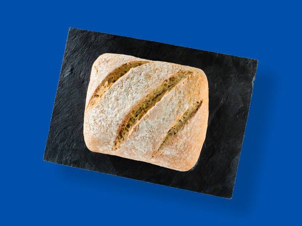 Pâine proaspătă, artizanală, pe o tavă neagră de ardezie.