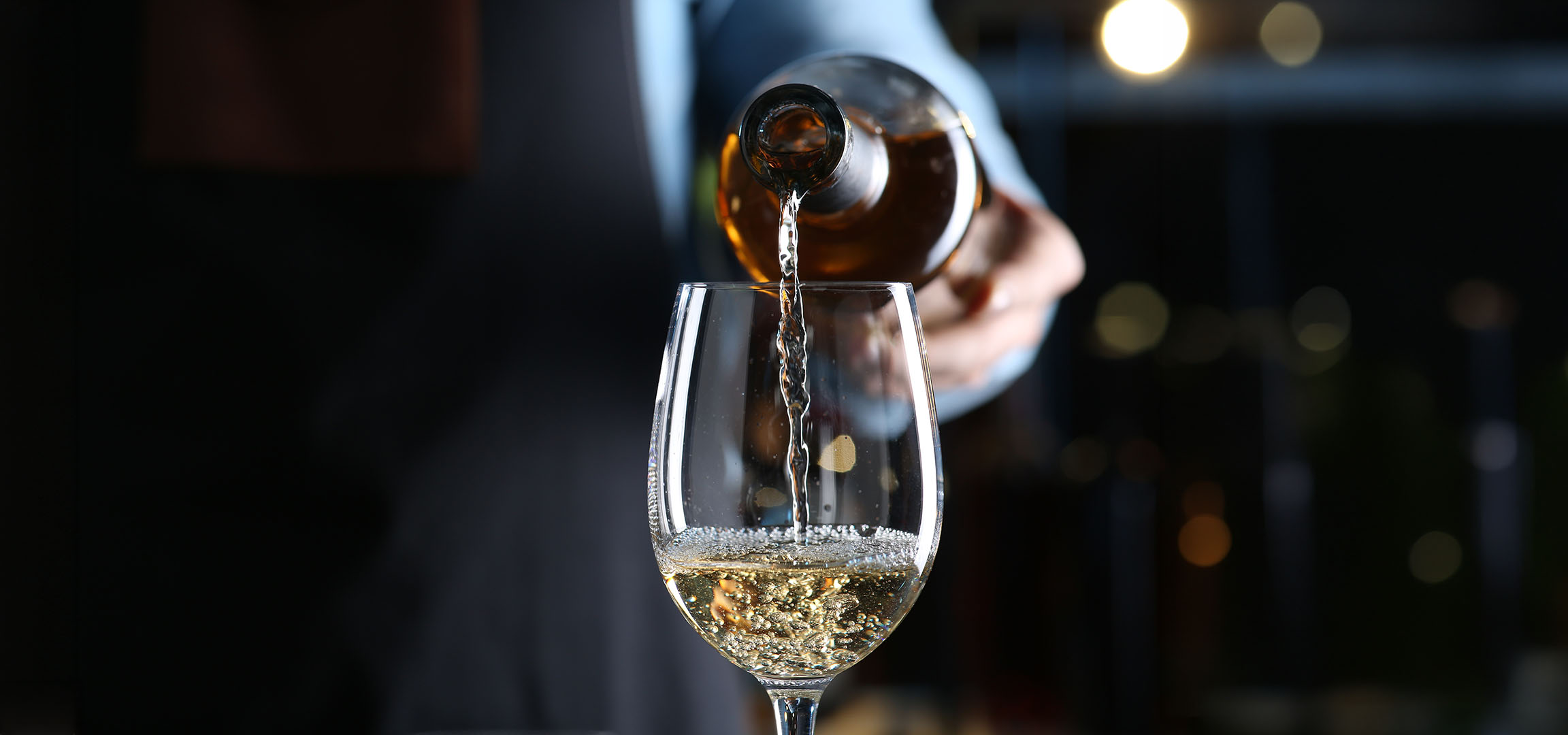 Vin alb turnat într-un pahar.
