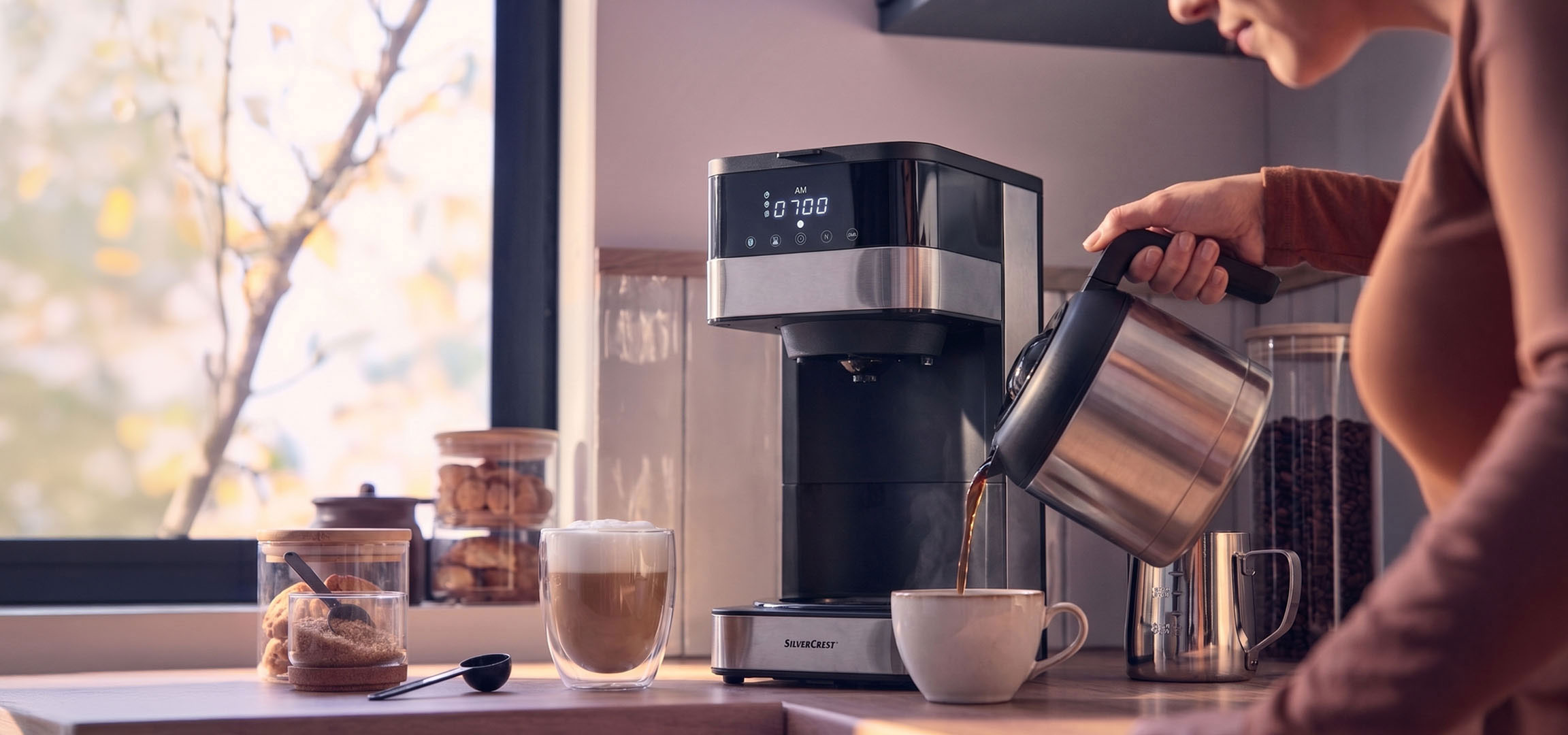 Generat de AI: Aparat de cafea turnând cafea într-o ceașcă, cu o fereastră luminoasă în fundal.