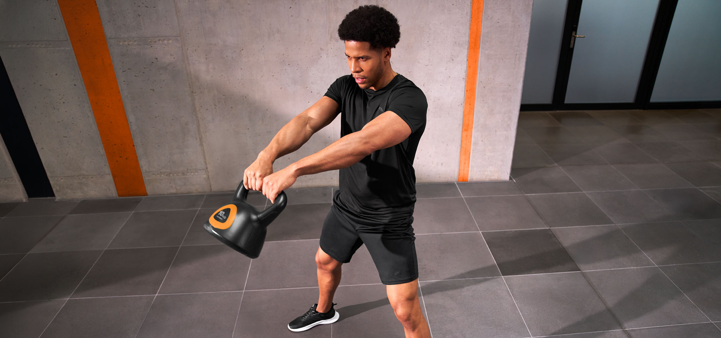 Generat de AI: Bărbat care se antrenează cu o ganteră kettlebell neagră cu portocaliu.