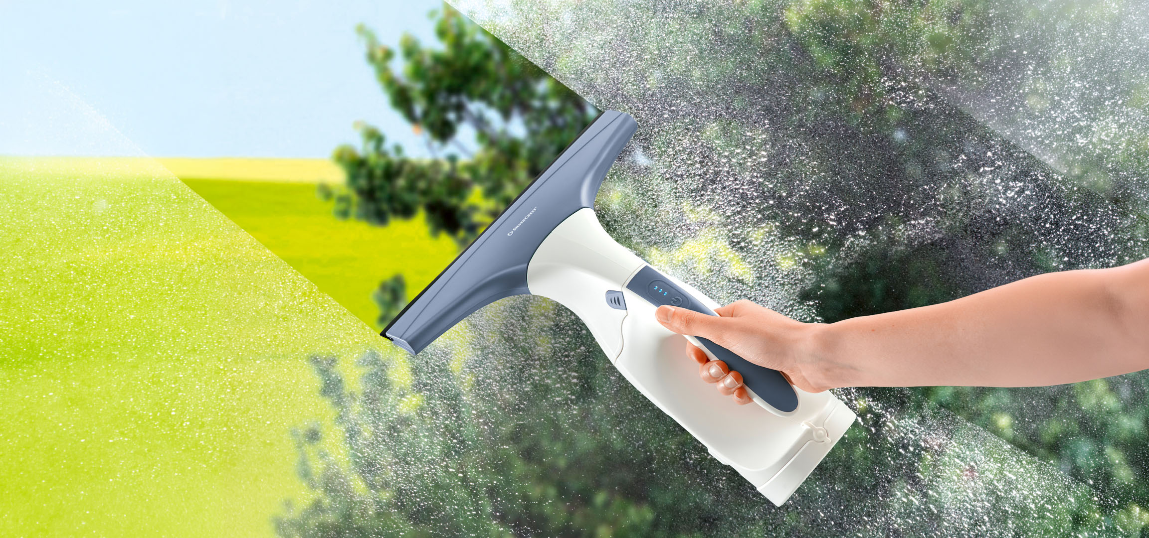 Mână care curăță o fereastră murdară cu un aspirator electric pentru geamuri.